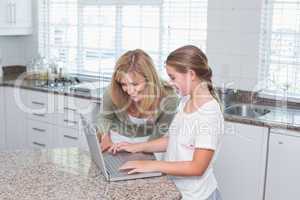 Mother and daughter using laptop together