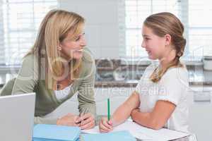 Mother helping daughter doing homework