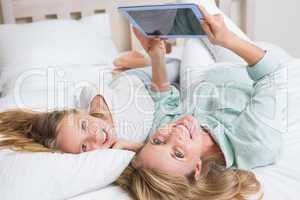 Happy mother and daughter using tablet