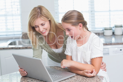 Mother and daughter using laptop together