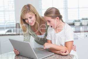 Mother and daughter using laptop together