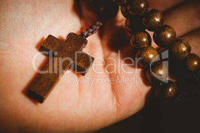 Hand holding wooden rosary beads