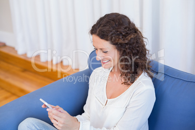 Smiling woman looking at her mobile phone