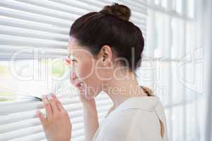 Woman peeking through the blinds