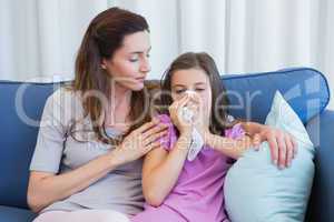 Mother helping daughter blow her nose