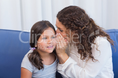 Mother and daughter whispering