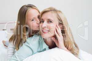 Cute girl kissing her smiling mother