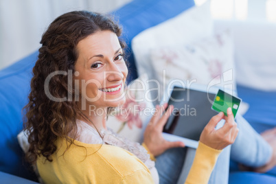 Pretty brunette relaxing on the couch with tablet