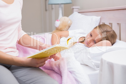 Mother reading daughter a bedtime story