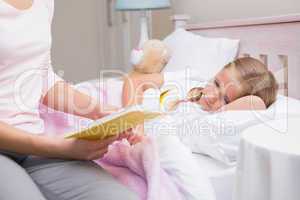 Mother reading daughter a bedtime story