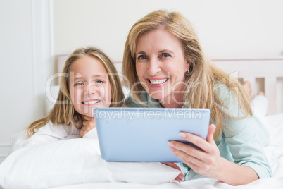 Happy mother and daughter using tablet