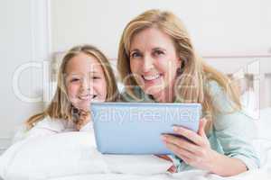 Happy mother and daughter using tablet