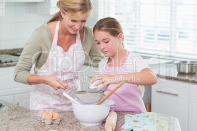 Mother and daughter making cake together