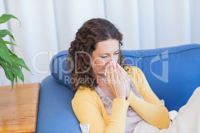 Sick woman blowing her nose