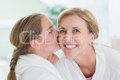 Pretty little girl kissing her mother on cheek