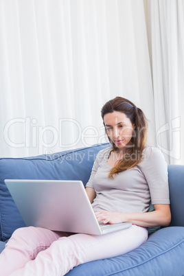 Casual woman using laptop on couch