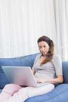 Casual woman using laptop on couch