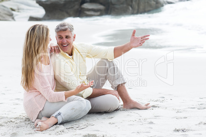 Happy couple sitting on the sand