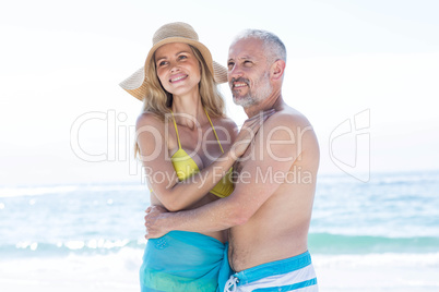 Happy couple standing by the sea and hugging each other