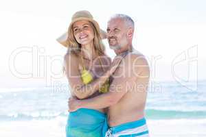 Happy couple standing by the sea and hugging each other