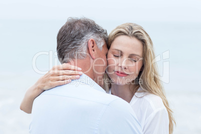 Happy couple hugging each other by the sea