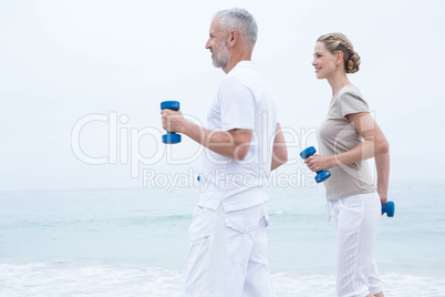 Fit couple lifting dumbbells