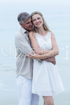 Happy couple standing by the sea and hugging each other