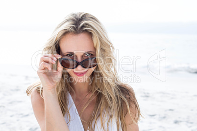 Smiling blonde in white dress wearing sun glasses