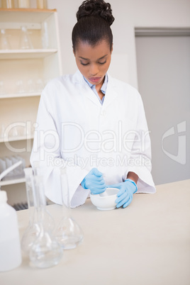 Concentrated scientist using pestle and mortar