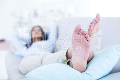 Smiling beautiful brunette relaxing on the couch