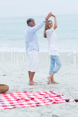 Happy couple dancing by the sea