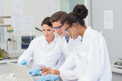 Scientists looking at laptop together