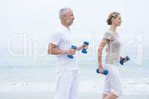 Fit couple lifting dumbbells