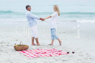 Happy couple standing by the sea and holding hands