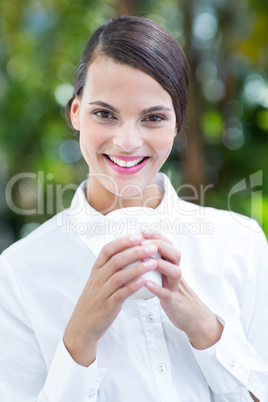 Pretty brunette drinking coffee and looking at camera