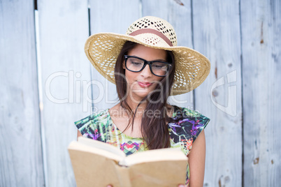 Smiling beautiful brunette reading a book