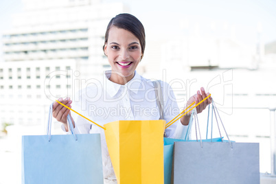 Happy woman looking inside shopping bags
