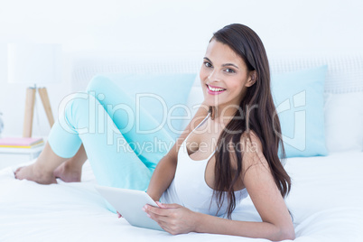 Beautiful woman using tablet pc on her bed