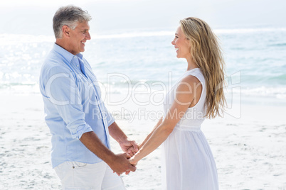 Happy couple holding hands and smiling at each other