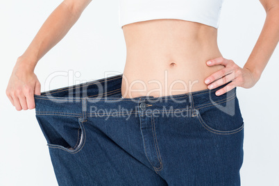 Slim woman wearing too big jeans