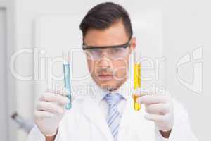Scientist examining precipitates in tubes