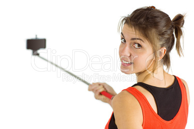 Casual brunette using selfie stick