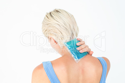 Blonde woman putting gel pack on neck