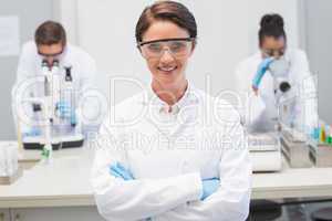 Happy scientist smiling at camera with protective glasses