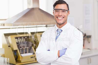 Happy scientist smiling at camera with arms crossed