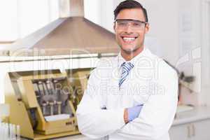 Happy scientist smiling at camera with arms crossed