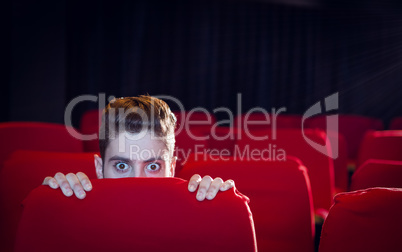 Young man watching a scary film