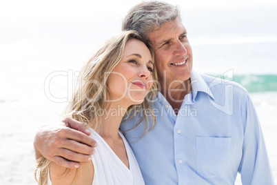 Happy couple standing by the sea