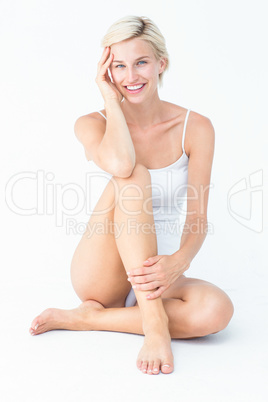 Gorgeous blonde sitting on the floor smiling at camera