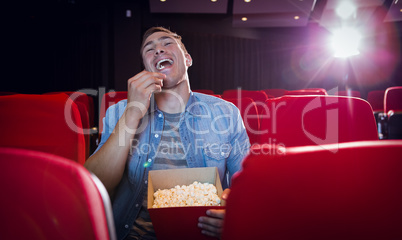 Happy young man watching a film